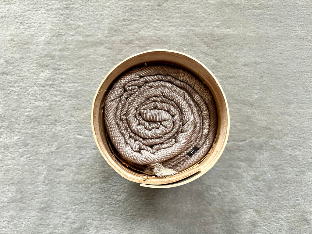 Le Grand Krama Doux Beige dans son écrin en écorce de palmier