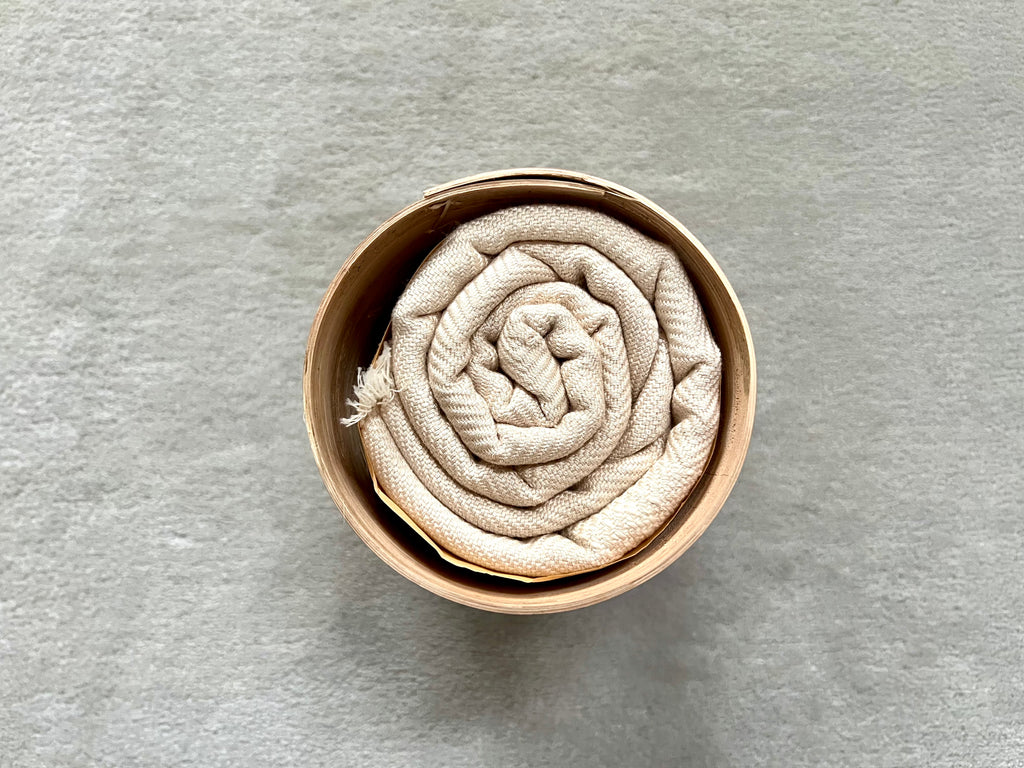 Le Grand Krama Doux Crème dans son écrin en écorce de palmier