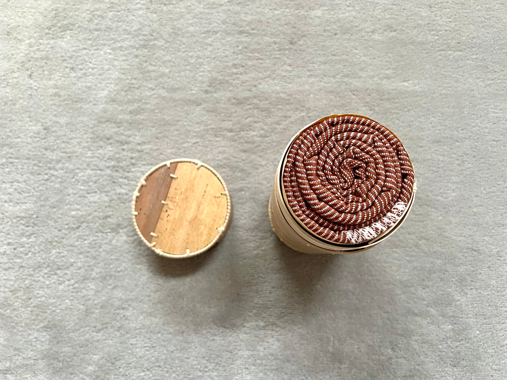 Le Krama Doux Marron dans son écrin en écorce de palmier