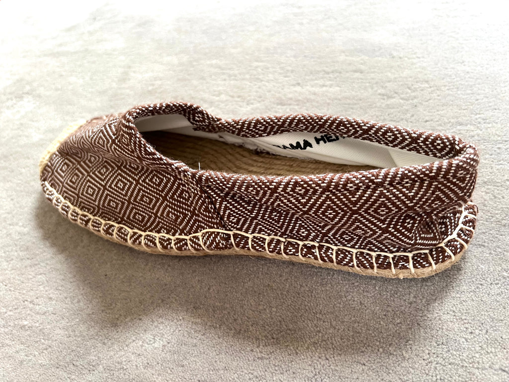 Les espadrilles Diamond Bronze dans leur grand écrin naturel en feuille de palmier