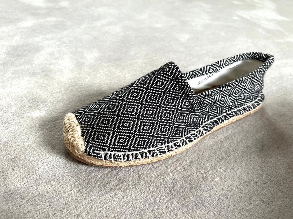 Les espadrilles Diamond Noir Ebène dans leur grand écrin naturel en feuille de palmier