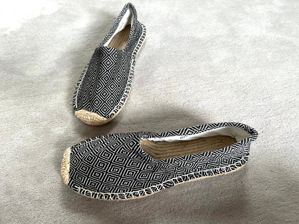 Les espadrilles Diamond Noir Ebène dans leur grand écrin naturel en feuille de palmier