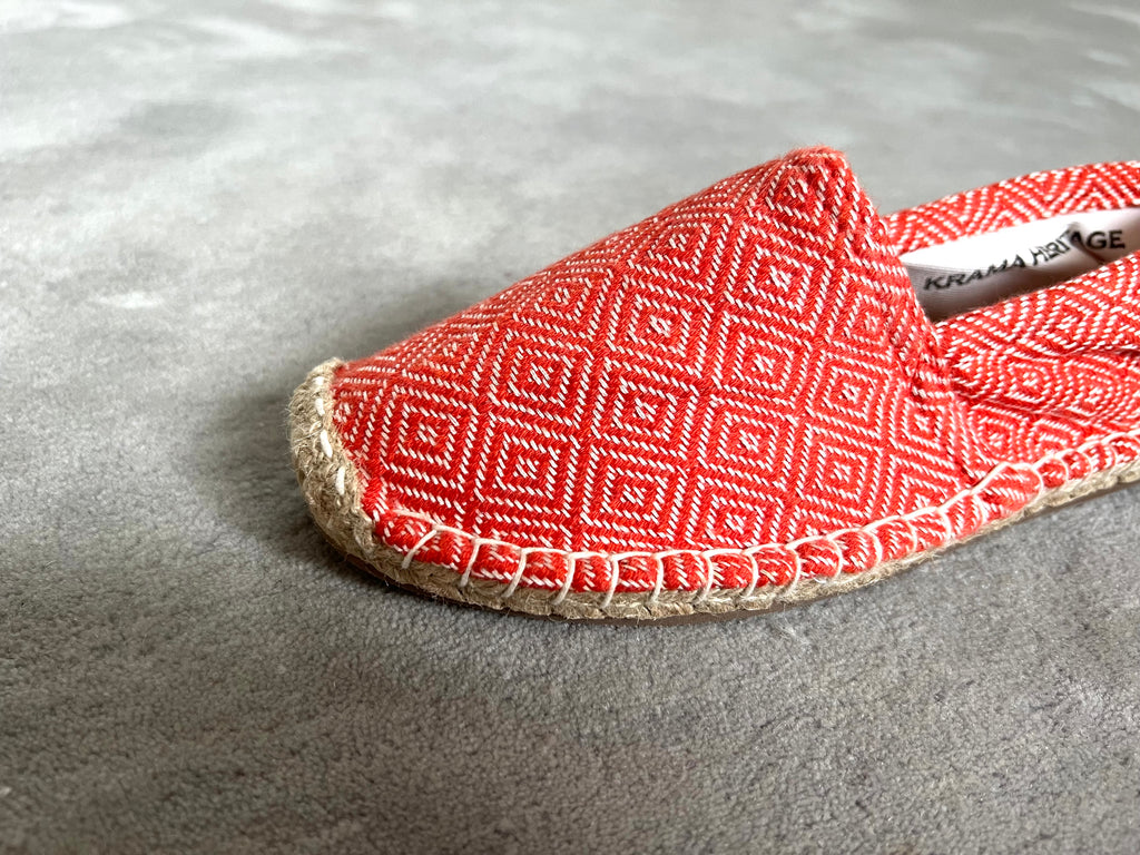 Les espadrilles Diamond Orange Corail dans leur grand écrin naturel en feuille de palmier