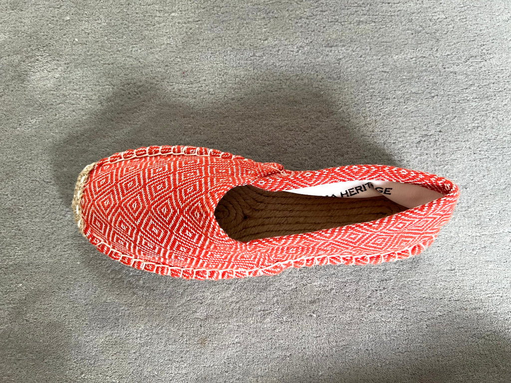 Les espadrilles Diamond Orange Corail dans leur grand écrin naturel en feuille de palmier