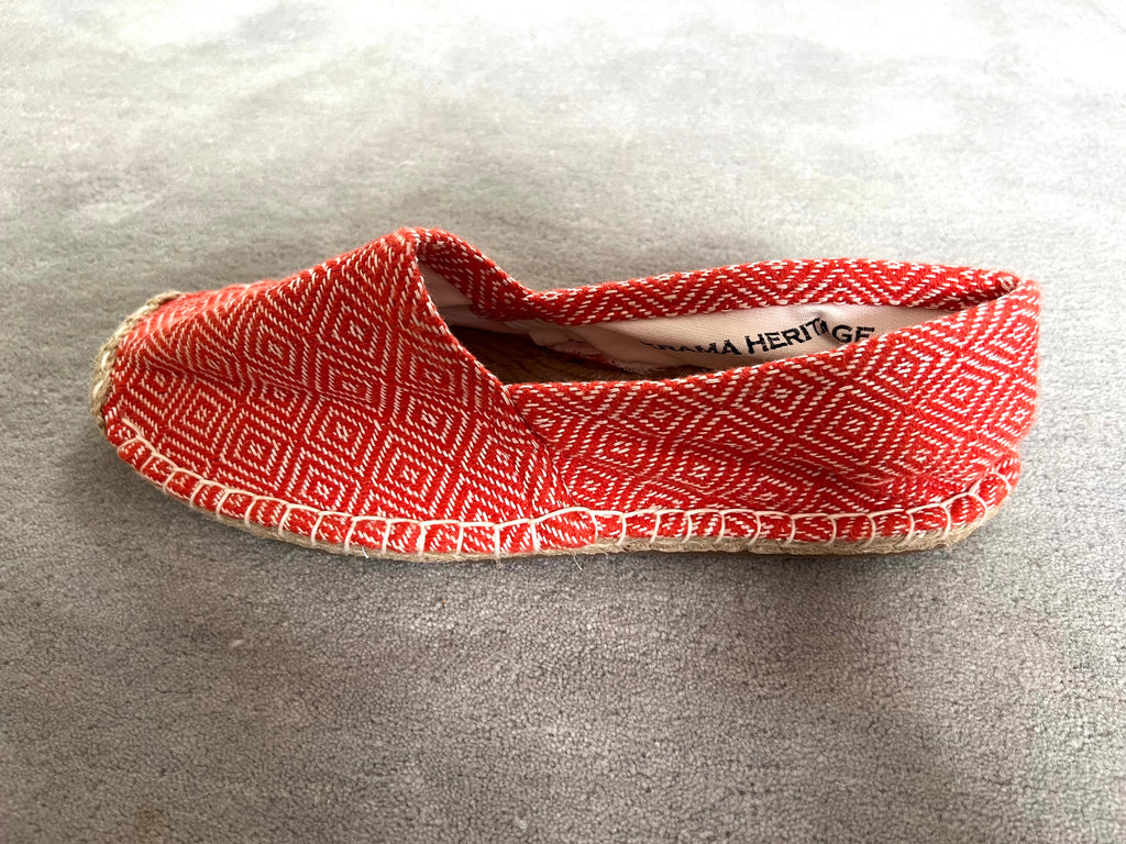Les espadrilles Diamond Orange Corail dans leur grand écrin naturel en feuille de palmier