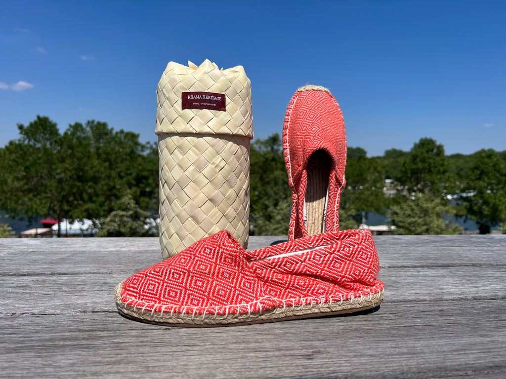 Les espadrilles Diamond Orange Corail dans leur grand écrin naturel en feuille de palmier