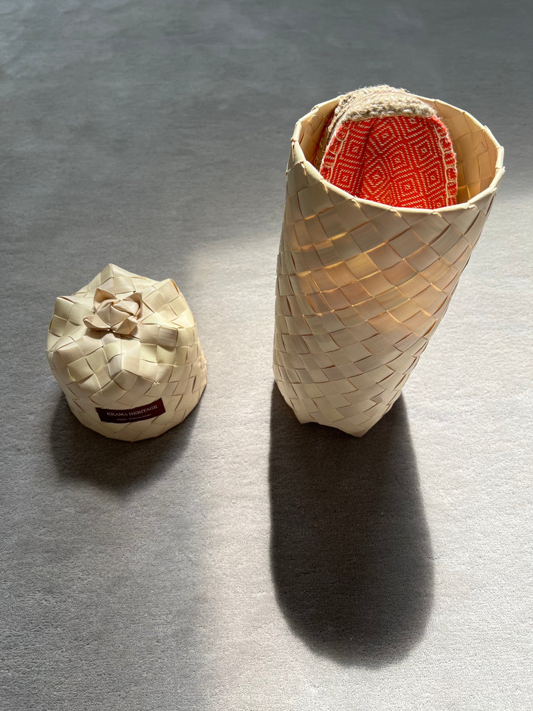 Les espadrilles Diamond Orange Corail dans leur grand écrin naturel en feuille de palmier