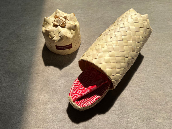 Les espadrilles Diamond Rouge Coquelicot dans leur grand écrin naturel en feuille de palmier