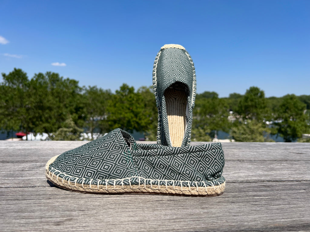 Les espadrilles Diamond Vert Forêt dans leur grand écrin naturel en feuille de palmier