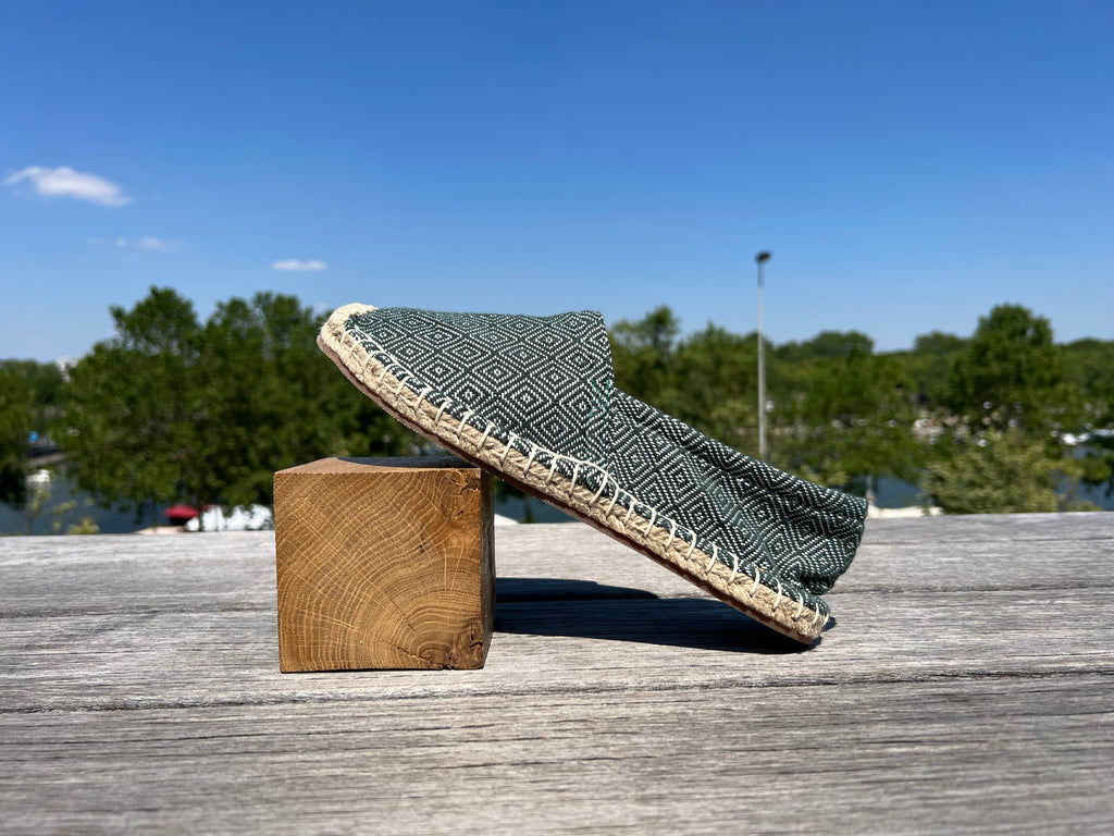 Les espadrilles Diamond Vert Forêt dans leur grand écrin naturel en feuille de palmier