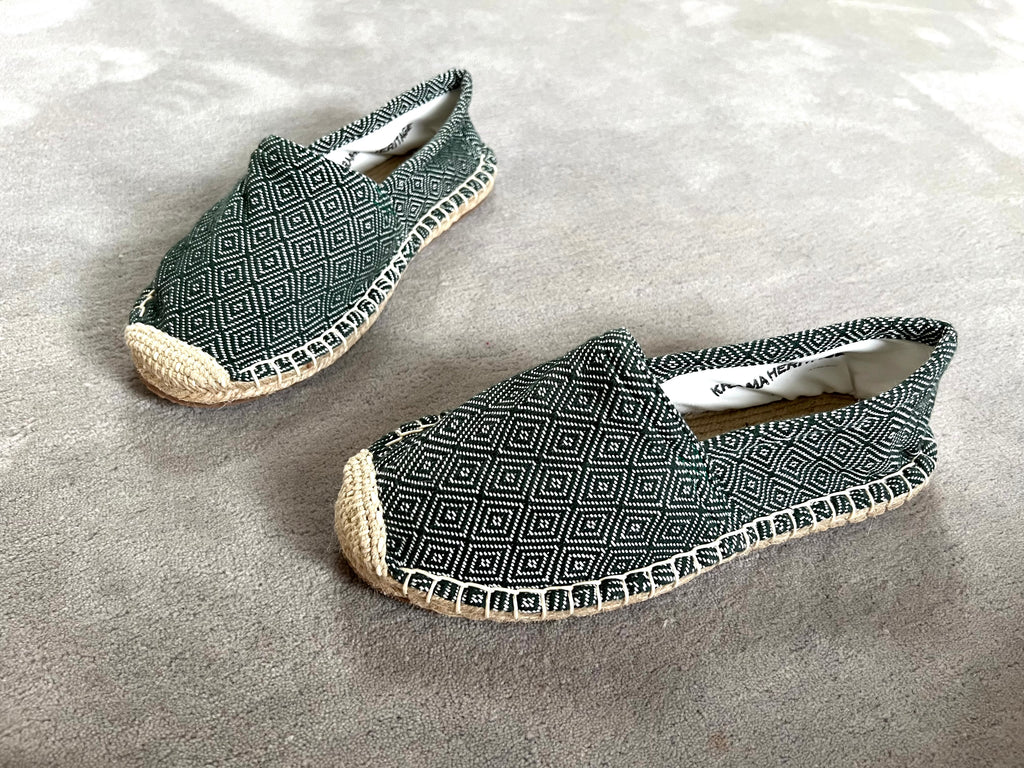Les espadrilles Diamond Vert Forêt dans leur grand écrin naturel en feuille de palmier