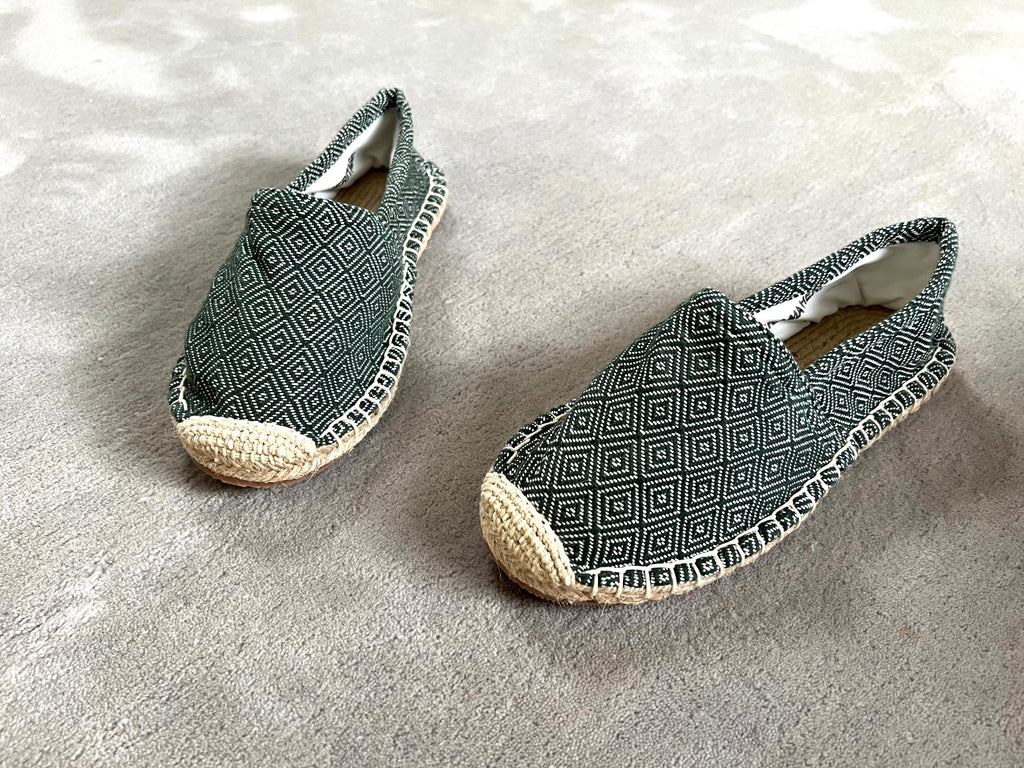 Les espadrilles Diamond Vert Forêt dans leur grand écrin naturel en feuille de palmier