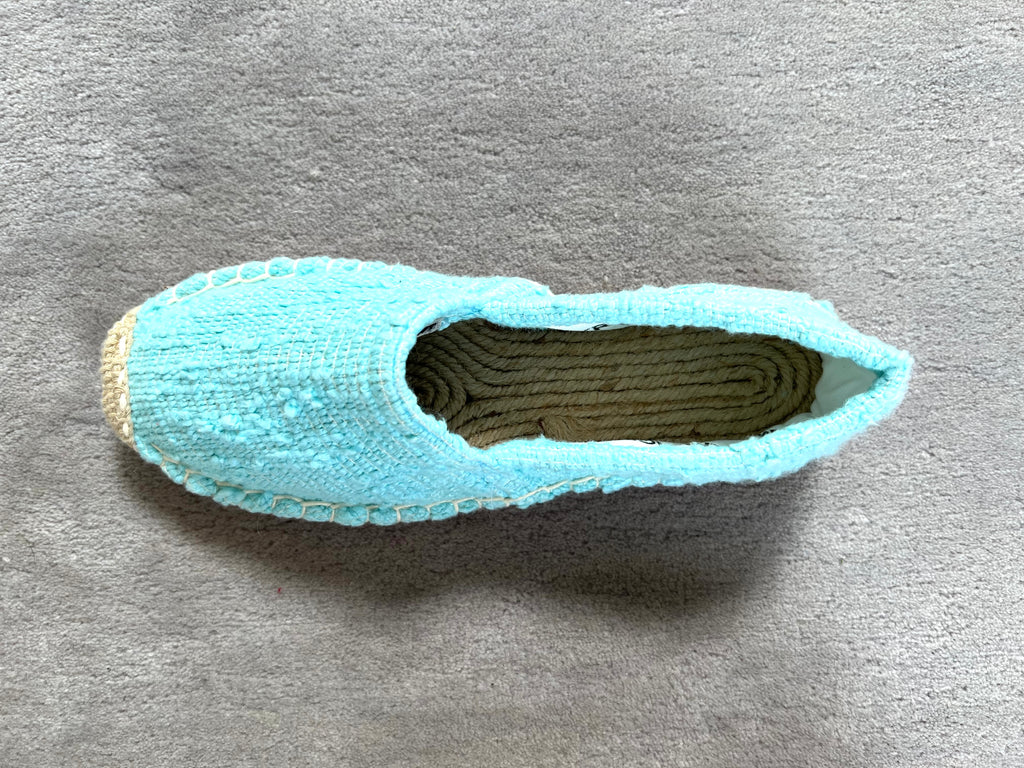 Les espadrilles Naturelles Cyan dans leur grand écrin naturel en feuille de palmier