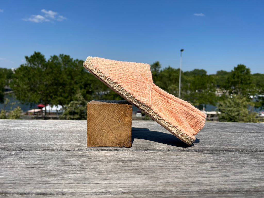 Les espadrilles Naturelles Pêche dans leur grand écrin naturel en feuille de palmier