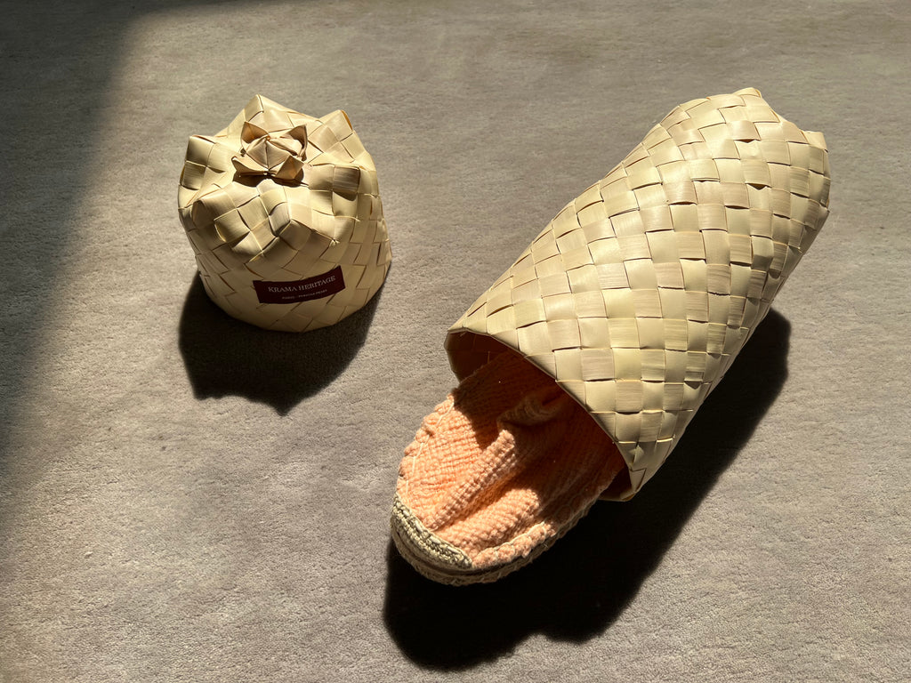 Les espadrilles Naturelles Pêche dans leur grand écrin naturel en feuille de palmier