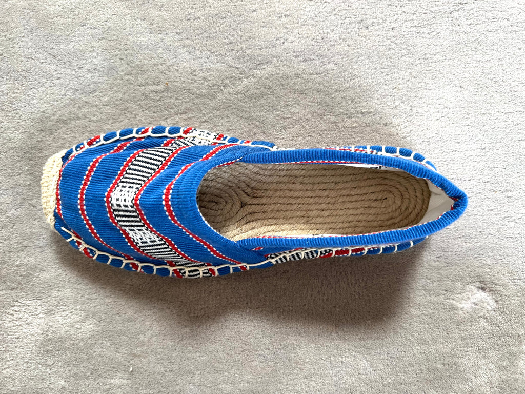 Les espadrilles Ratanakiri Bleu Roi dans leur grand écrin naturel en feuille de palmier