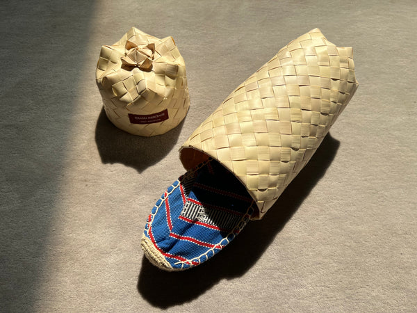 Les espadrilles Ratanakiri Bleu Roi dans leur grand écrin naturel en feuille de palmier