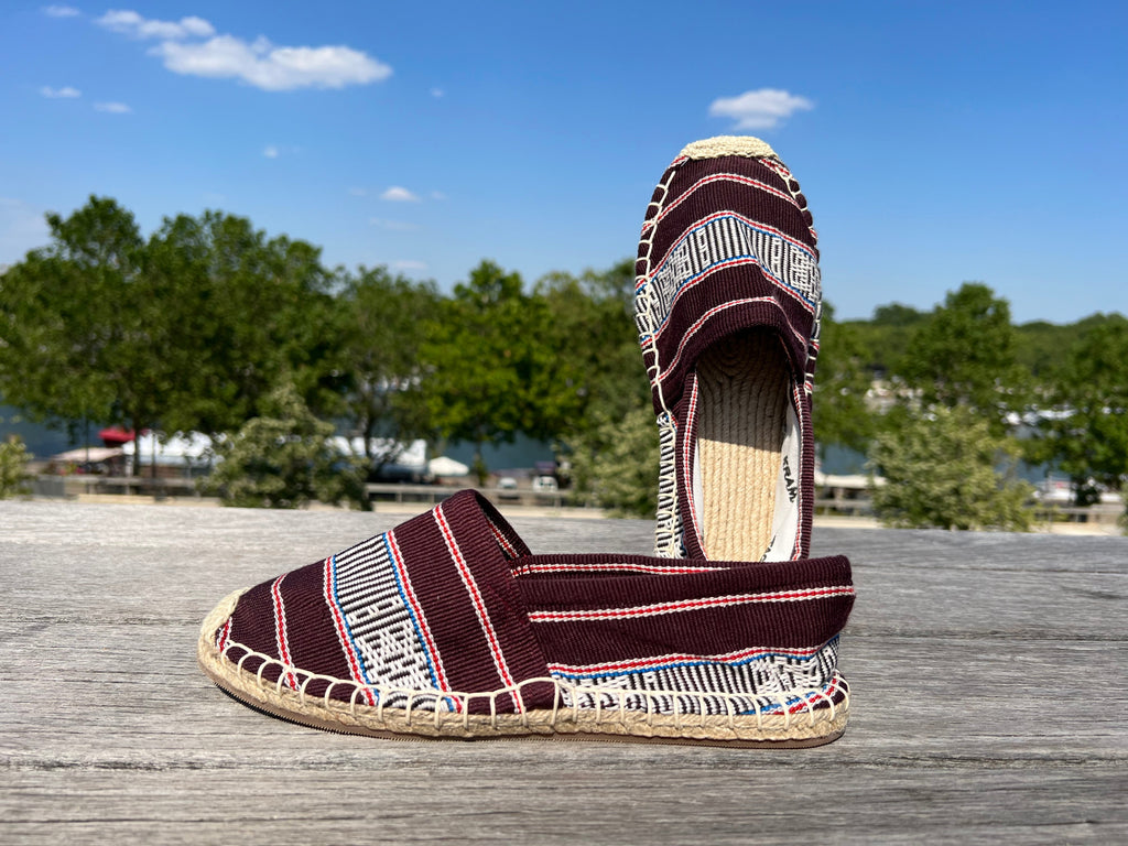 Les espadrilles Ratanakiri Bordeaux dans leur grand écrin naturel en feuille de palmier