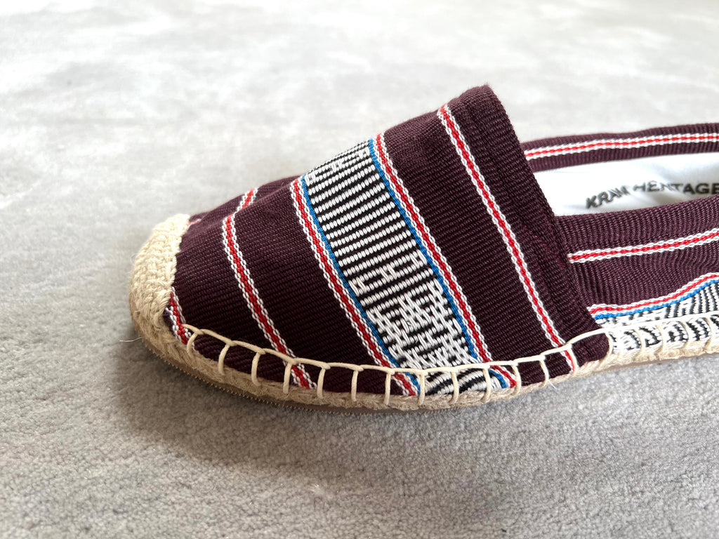 Les espadrilles Ratanakiri Bordeaux dans leur grand écrin naturel en feuille de palmier