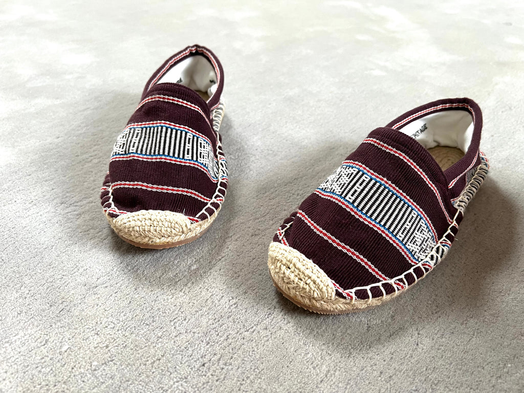 Les espadrilles Ratanakiri Bordeaux dans leur grand écrin naturel en feuille de palmier