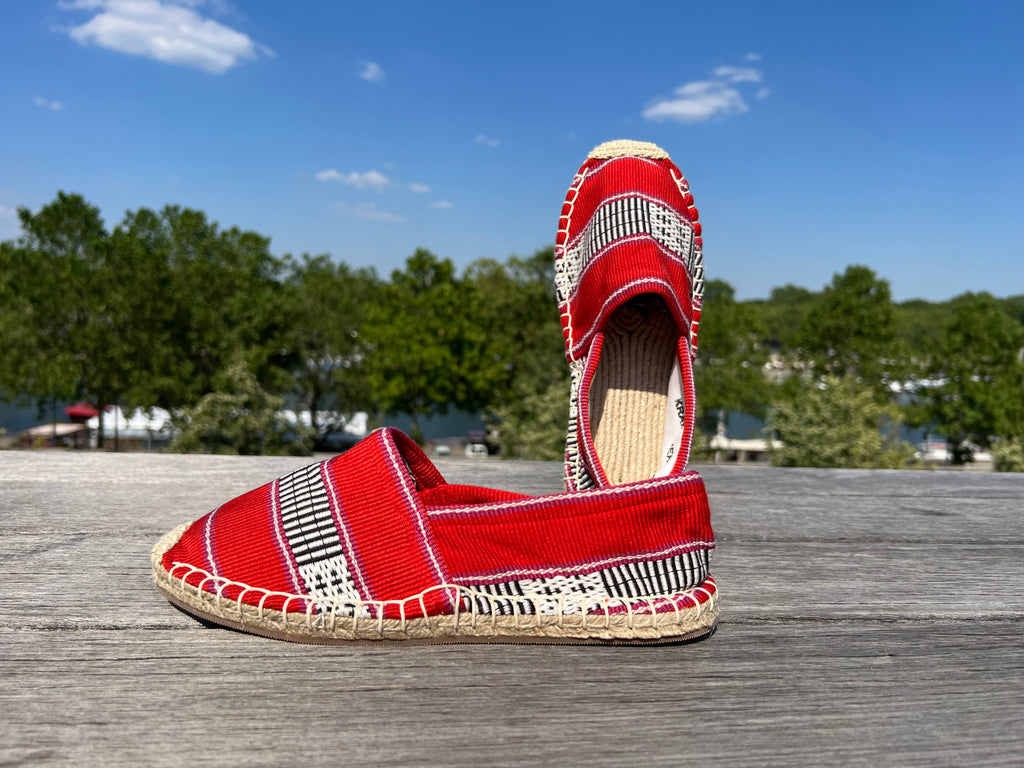 Les espadrilles Ratanakiri Coquelicot dans leur grand écrin naturel en feuille de palmier