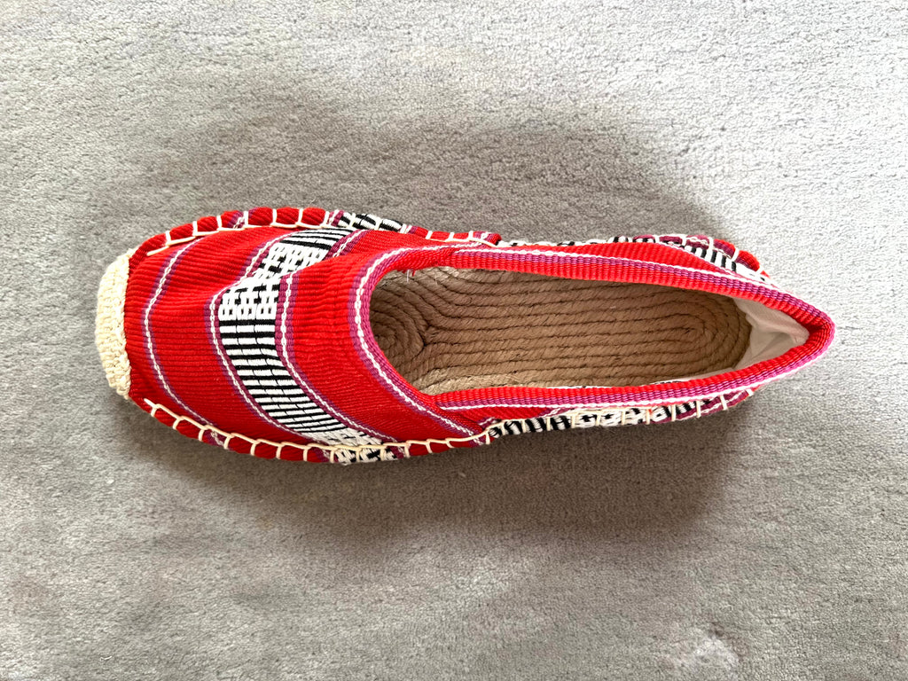 Les espadrilles Ratanakiri Coquelicot dans leur grand écrin naturel en feuille de palmier
