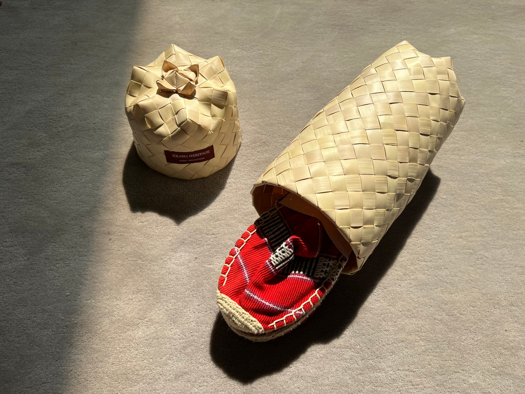 Les espadrilles Ratanakiri Coquelicot dans leur grand écrin naturel en feuille de palmier