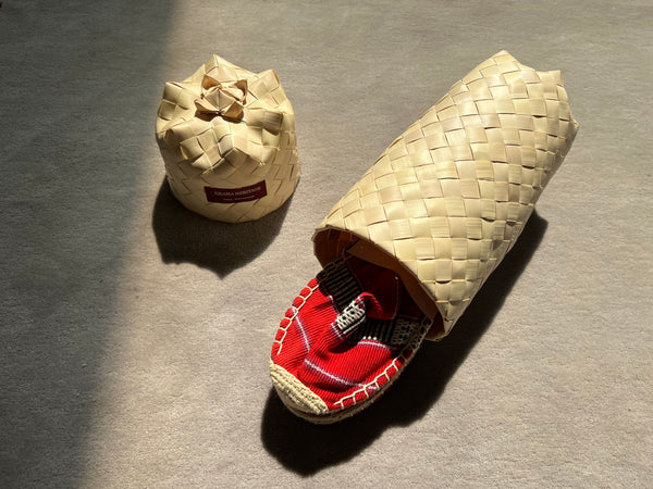 Les espadrilles Ratanakiri Coquelicot dans leur grand écrin naturel en feuille de palmier