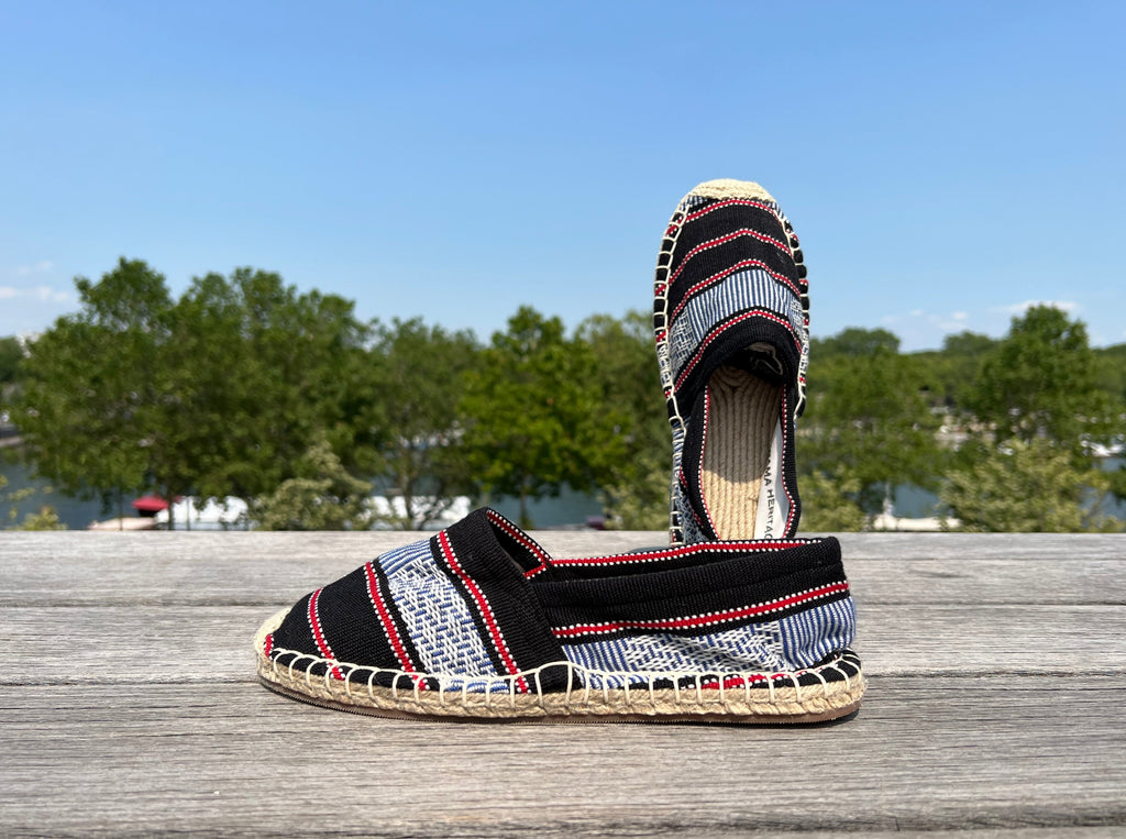 Les espadrilles Ratanakiri Réglisse dans leur grand écrin naturel en feuille de palmier