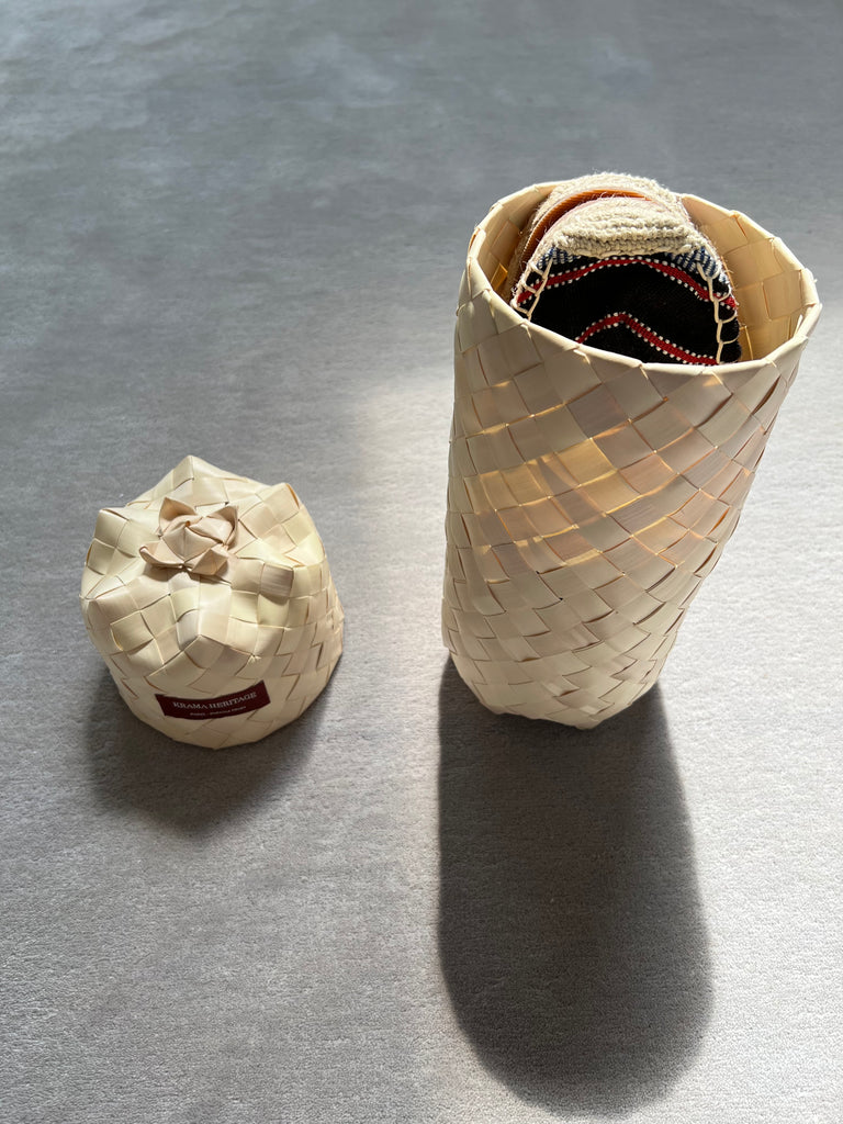 Les espadrilles Ratanakiri Réglisse dans leur grand écrin naturel en feuille de palmier