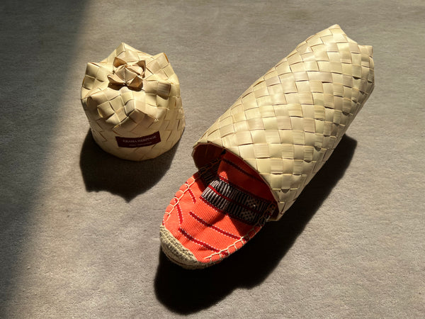 Les espadrilles Ratanakiri Saumon dans leur grand écrin naturel en feuille de palmier